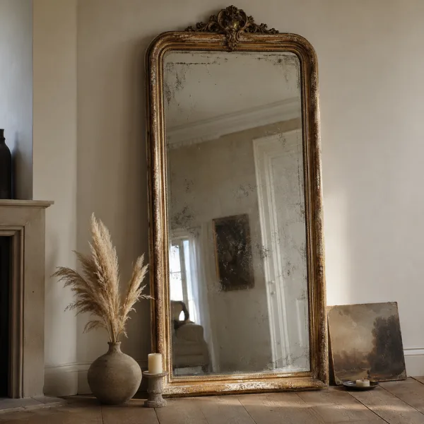Vintage Distressed Gilt Mirror Against a Neutral Wall Styled to Glow the Vintage Distressed Gilt Mirror Against a Neutral Wall